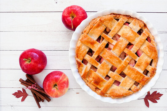 Homemade autumn apple pie. Top view table scene over a white wood background.