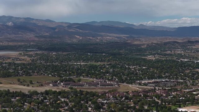 Aerial of sprawling suburban community in Larimer County Loveland Colorado with dense residential development in summer and mountain backdrop