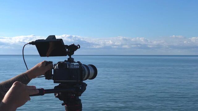 Videographer filming boat, side view with camera rig above calm sea, showing marine footage production, travel media, maritime content creation and coastal videography for tourism projects