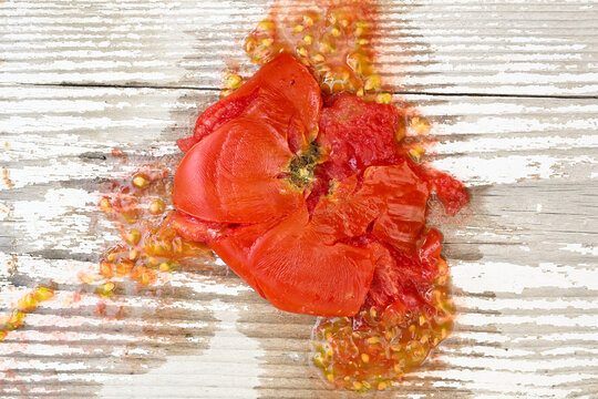 smashed red tomato splatter on weathered wooden background