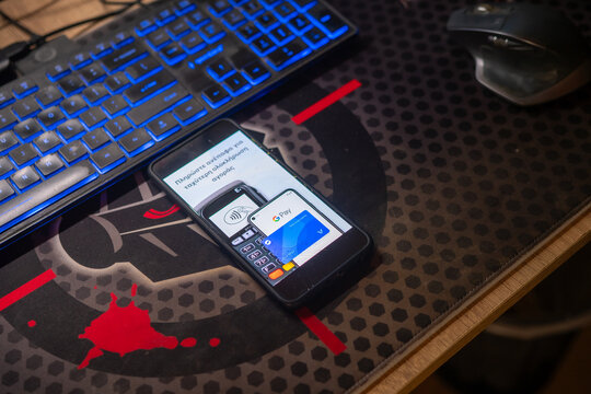 Smartphone screen displaying Google Pay contactless payment interface setup on office desk with keyboard for nfc banking and financial transaction concept