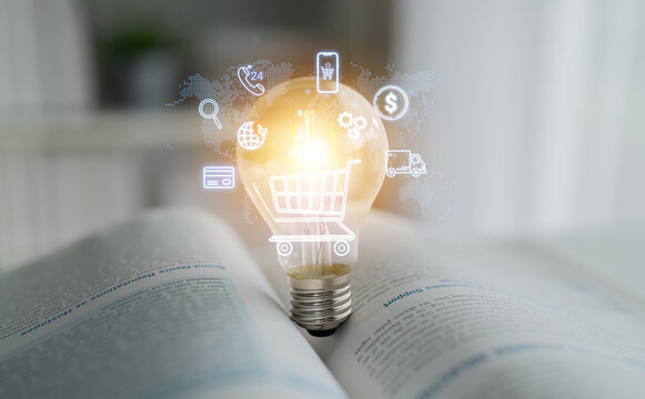 Innovative Light Bulb Representing Business Ideas and E-commerce Concepts with Digital Icons on Open Book Background. Entropy.