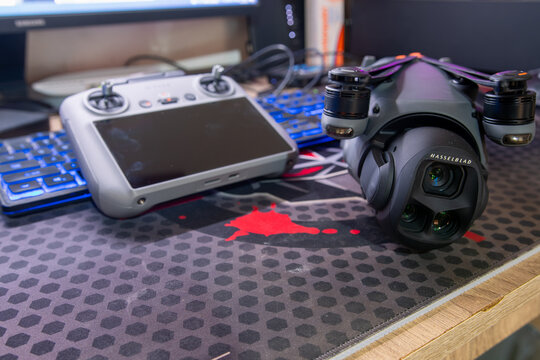 Professional DJI Mavic 4 Pro drone with Hasselblad 100MP 4/3 CMOS camera and DJI RC 2 remote controller on office desk in technology concept
