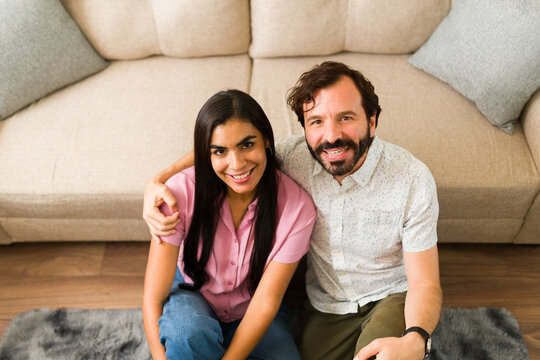Young man and woman dating at home, embracing and smiling, enjoying a romantic moment in their living room