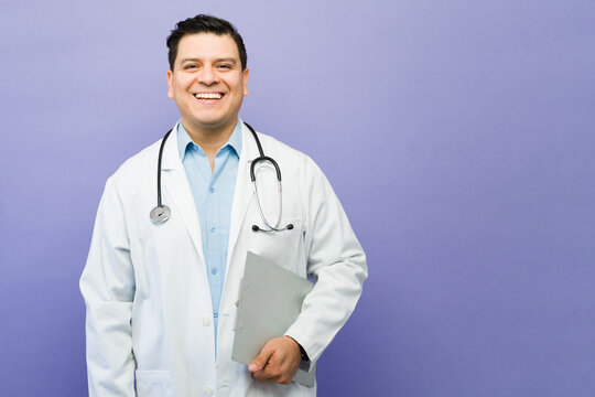 Latin doctor smiling and holding clipboard, providing healthcare and medical assistance to patients