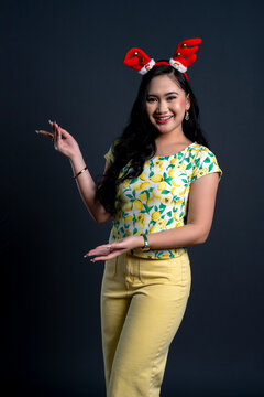 Portrait of young woman in yellow theme cloth with Christmas headband