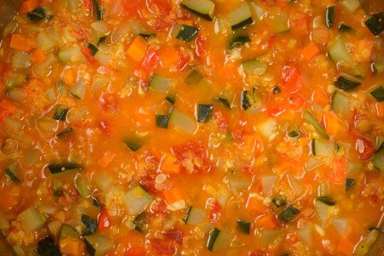 Full frame background texture of a freshly cooked vegetable stew with chopped zucchini tomatoes and carrots