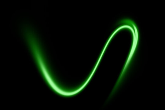 Abstract glowing green light trail on black background