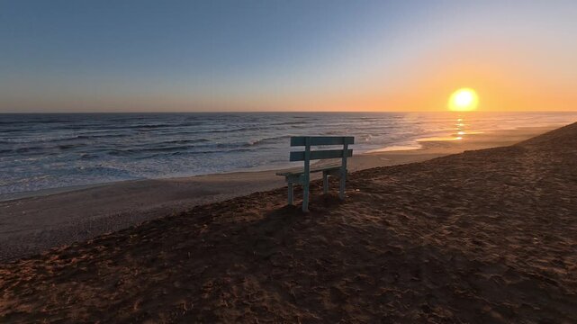 A solitary, empty bench on the Atlantic coast at sunset, Namibia, Africa.