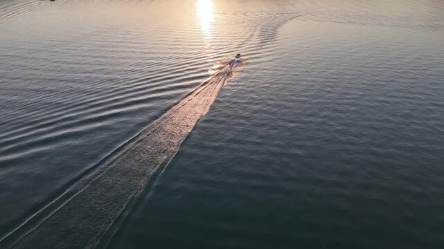 Aerial view of person being towed behind a motorboat on a lake