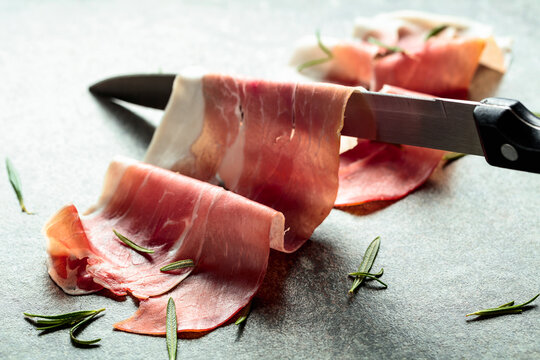 Delicious prosciutto slices topped with fresh rosemary.