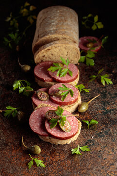 Sandwiches with smoked sausage on a vintage background.