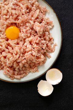 Minced meat with egg yolk on plate and eggshells