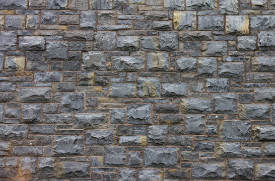 A section of wall made of grey cut stone