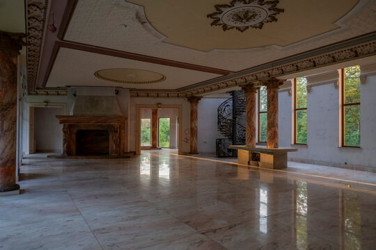 Abandoned luxury mansion interior with marble hall, ornate fireplace, swimming pool and glass facade