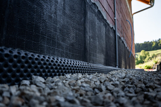 Waterproofing membrane applied to the foundation wall of a house under construction