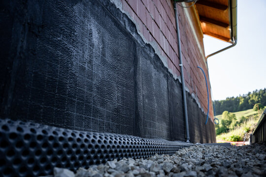 Waterproofing membrane applied to the foundation wall of a house under construction