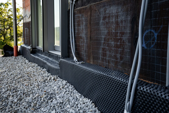Waterproofing membrane applied to the foundation wall of a house under construction
