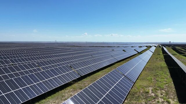 Rows of solar photovoltaic panels in a large scale power generation station under blue sky