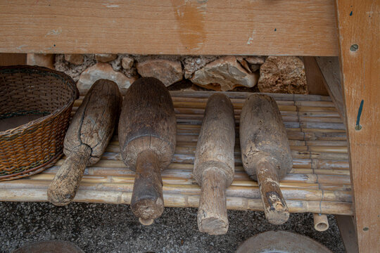 Traditional wooden mallets resting on a bamboo shelf for grape crushing in Spain
