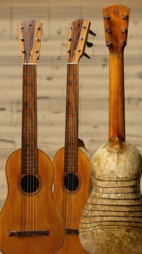 Traditional Charango and Vintage Acoustic String Instruments on Sheet Music Background