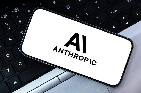 Illustrative editorial of anthropic ai logo on mobile phone screen over laptop keyboard