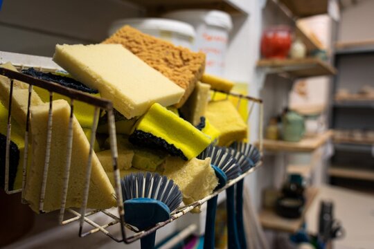 Sponges and brushes drying beside a pottery studio sink