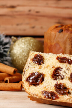 Sliced ​​chocolate cream filled panettone for a Christmas celebration, set on a rustic, ornate wooden table.