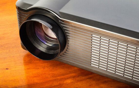 Photo of a table led projector device on wooden table surface.