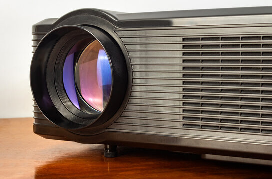 Photo of a table led projector device on wooden table surface.