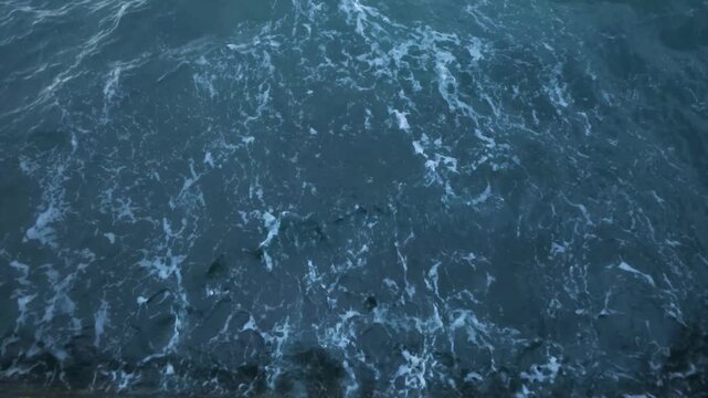 Close Up View of Turbulent Dark Blue Sea Waves Crashing into White Foam and Splashing Drops, Abstract Ocean Water Surface Motion, Nature Background Travel Stock Footage