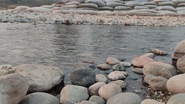 Natural river stones with flowing water during golden hour soft light