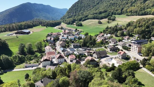 Sunlit village nestled among rolling green hills
