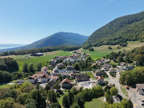 Sunlit village nestled among rolling green hills