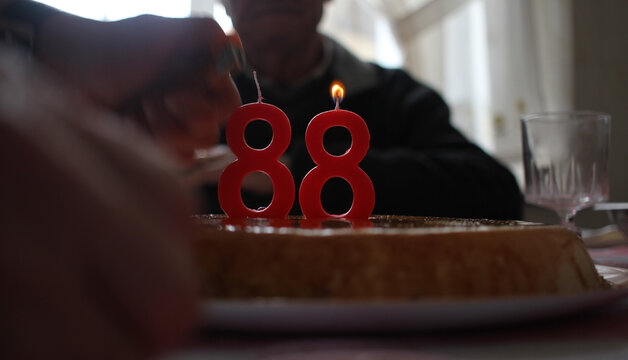 Lighting number 88 candles on a birthday cake for an elderly celebration