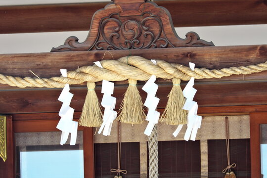 Shimenawa rope and shide paper at Shinto shrine entrance