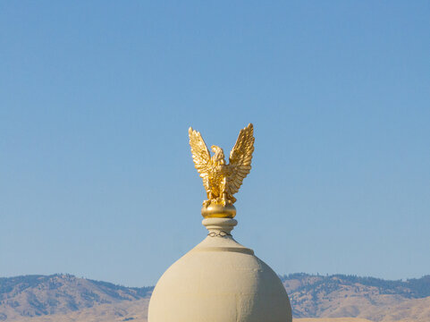 Eagle atop dome, peaceful landscape, sunny day, architectural focus
