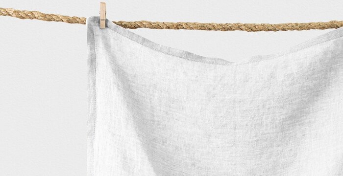 Minimal white linen fabric hanging on rope with clothespin