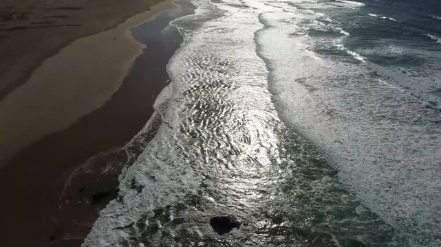 Sunlight reflecting on Atlantic waves at Praia da Bordeira in Portugal
