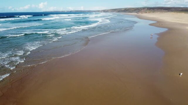 Aerial view of people on the vast Praia da Bordeira beach in Algarve