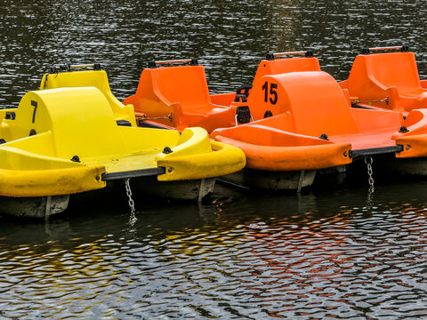 Vibrant recreational pedal boats floating on a peaceful river, evoking themes of summer vacation, outdoor leisure, and family weekend activities.