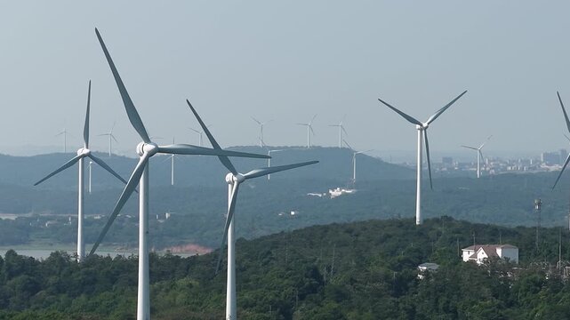 Rows of wind turbines on green hills