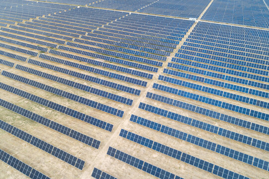 Large solar farm with rows of blue photovoltaic panels