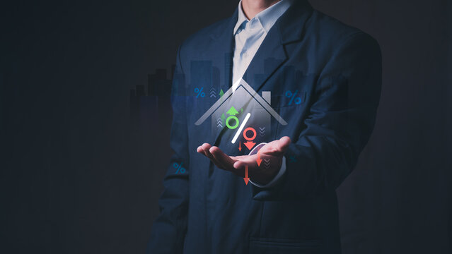 Businessman holding virtual house with percentage sign and arrows representing real estate market fluctuation, property investment, housing loan interest rate, and mortgage finance.