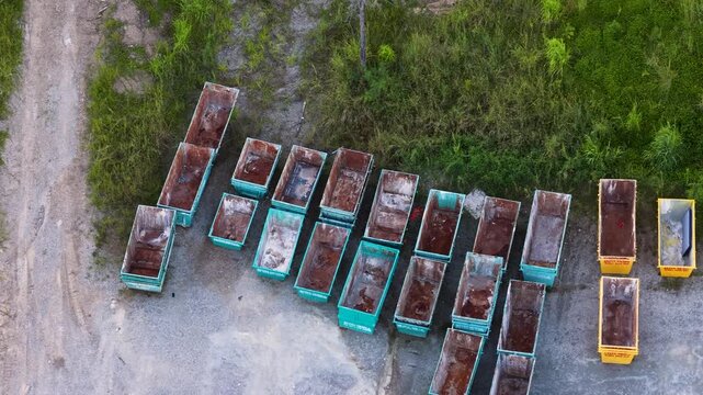 Aerial view of a scrap yard with rows of industrial dumpsters and bins.