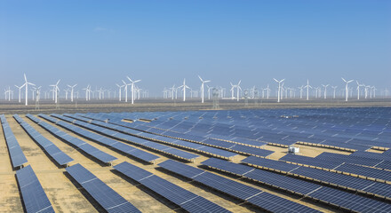 Obraz premium Solar Photovoltaic Farm and Wind Turbines in Desert Landscape