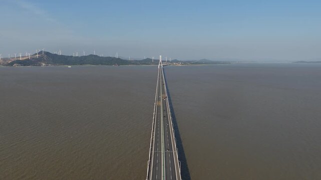 long sea bridge stretching towards distant mountains