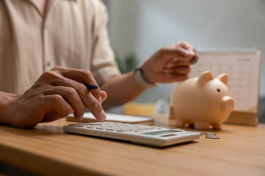 Personal finance planning at home with calculator, savings jar, calendar, and pen