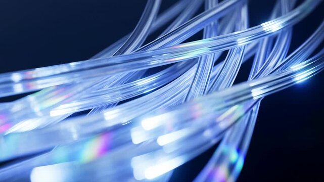 Clear fiber optic strands curve and overlap while glowing white tips and rainbow reflections glide across a dark blue background, forming layered luminous lines in close view