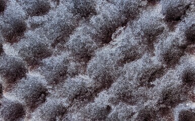 Macro texture of dark grey acoustic foam, acoustic panel surface detail. © Putu